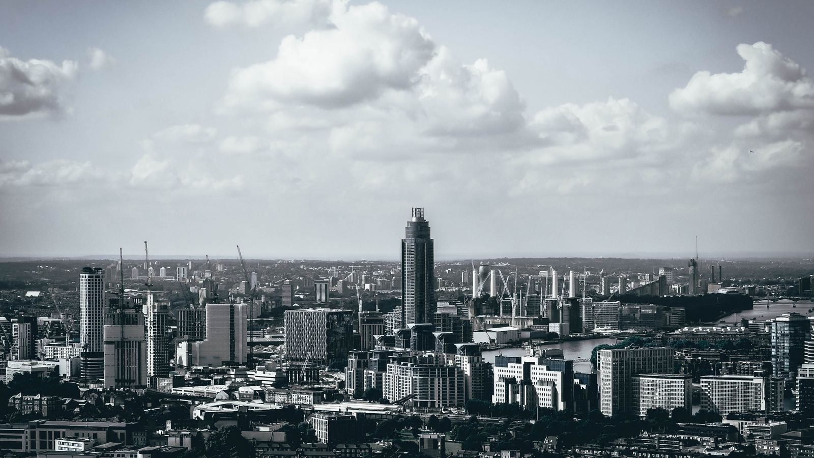 Monochrome view of the London skyline with the City's towers on the horizon.