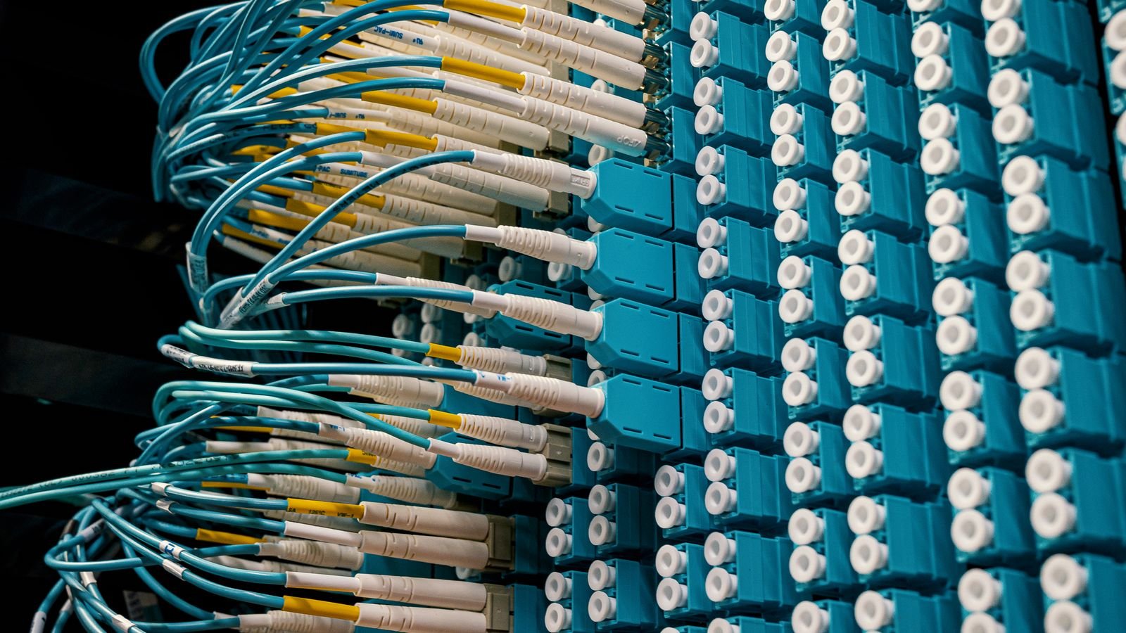 Fibre optic cables connected in ordered rows to a data centre patch panel.